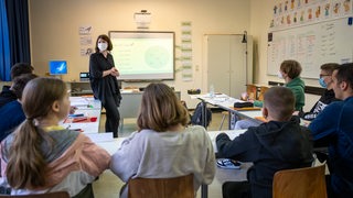 Schülerinnen und Schüler einer neu eingerichteten Willkommensklasse für aus der Ukraine geflüchtete Kinder am Lessing-Gymnasium sitzen in einem Klassenraum an ihren Tischen.