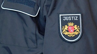 Auf dem Ärmel einer Jacke steht "Justiz".