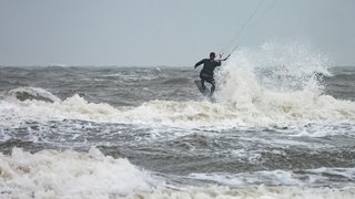 Kitesurfer ist bei stürmischem Wetter vor St. Peter Ording unterwegs