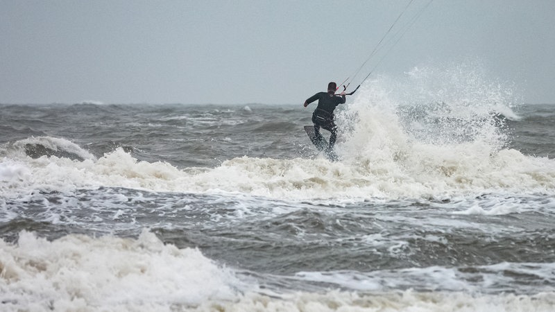 Kitesurfer ist bei stürmischem Wetter vor St. Peter Ording unterwegs