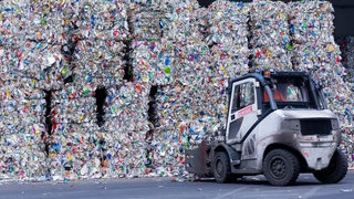 Sortierte Verpackungsabfälle stehen gepresst neben einer Halle, nachdem sie in der Sortieranlage des Entsorgungsunternehmens Remondis getrennt worden sind. 