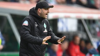 Werder-Trainer Ole Werner ruft und gestikuliert an der Seitenlinie.