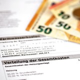 Geldscheine liegen neben einer Nebenkostenabrechnung