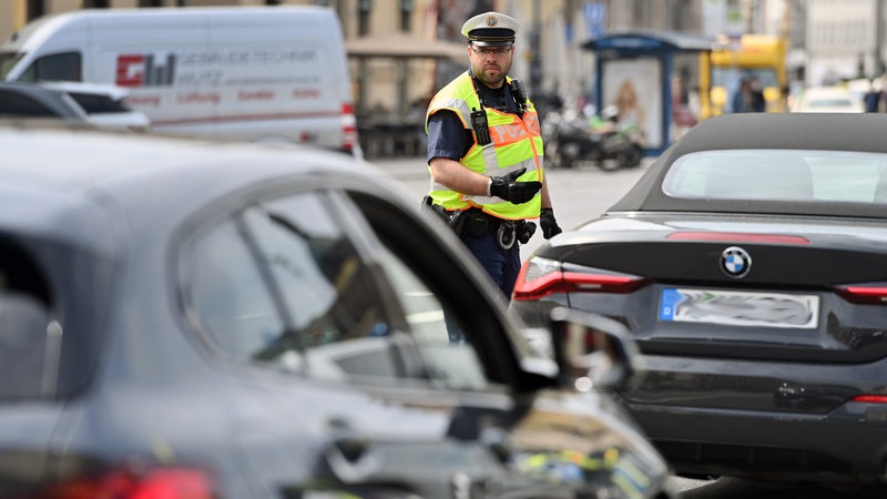 Ein Polizist kontrolliert Autofahrer.