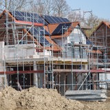 Haus mit Solaranlage auf dem Dach ist eingerüstet
