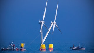 Monteure verankern für Testreihen das Modell einer Anlage mit schwimmende Windräder im Greifswalder Bodden.