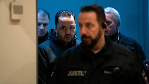 30.01.2019, Niedersachsen, Oldenburg: Der wegen Mordes an 100 Patienten angeklagte Niels Högel (2.v.l.) wird am Prozesstag von Justizvollzugsbeamten in den Gerichtssaal geführt.