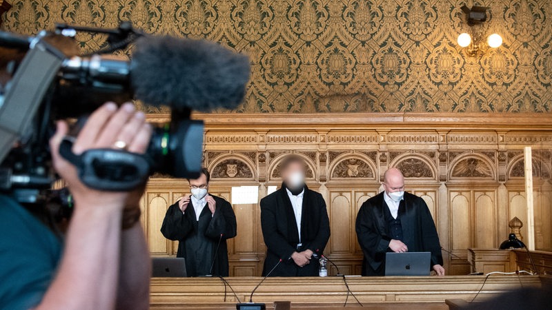 Mehrere Männer stehen im gerichtssaal des Landgerichts Bremen