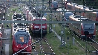 Züge der Deutschen Bahn (DB) stehen am Hauptbahnhof Dresden auf einem Gleis.