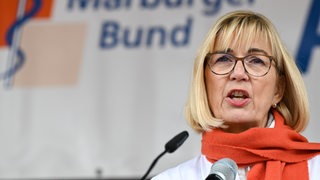 Eine Frau spricht auf einer Veranstaltung. 