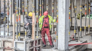 Zwei Männer arbeiten auf einer Baustelle