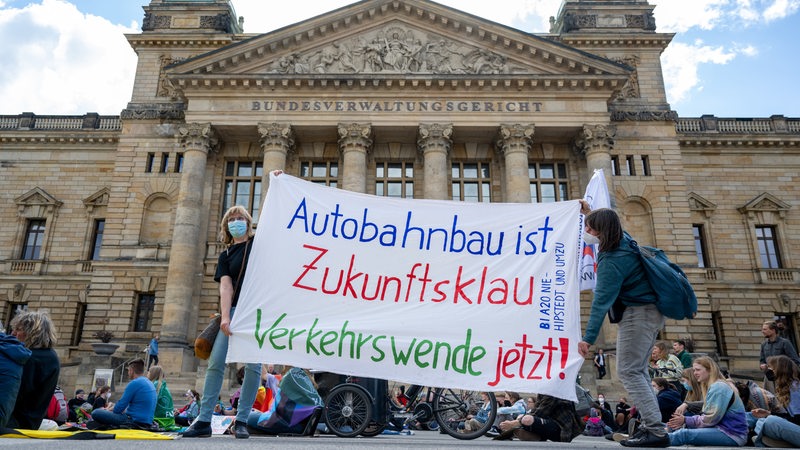 Teilnehmer einer Demonstration von BUND und Fridays for Future gegen den Bau der A20 in Niedersachsen und Schleswig-Holstein stehen vor dem Bundesverwaltungsgericht in Leipzig.