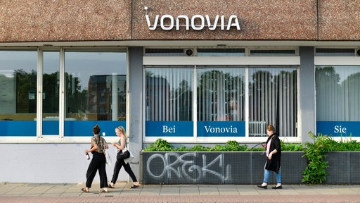 Mehrere Menschen schlendern vor der Bremer Vonovia-Zentrale entlang.