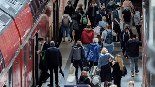 Fahrgäste steigen in einen Regional-Express ein und aus.