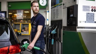 Ein junger Mann betankt sein Auto