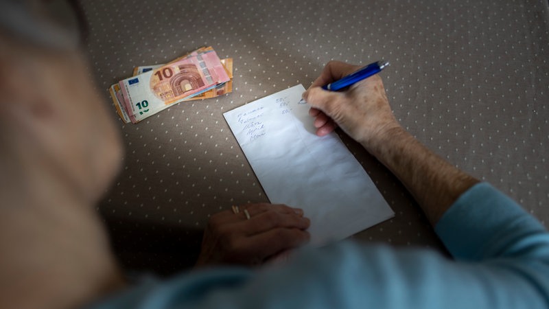 Eine Rentnerin stellt eine Übersicht über ihre Ausgaben auf.
