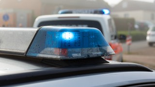 Ein Einsatzfahrzeug der Polizei steht mit Blaulicht an einem Unfallort (Symbolbild)