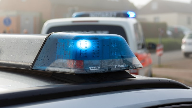 Ein Einsatzfahrzeug der Polizei steht mit Blaulicht an einem Unfallort