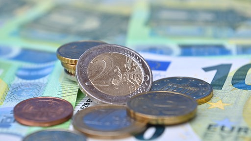 Euro-Münzen und Scheine liegen auf einem Tisch.