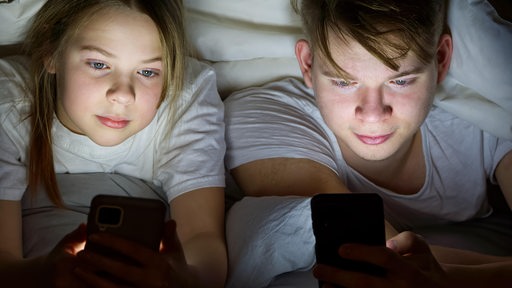 Zwei Kinder schauen auf ihre Smartphones