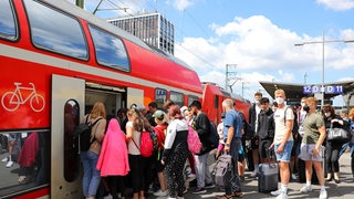 Fahrgäste steigen in einen Regionalzug ein.