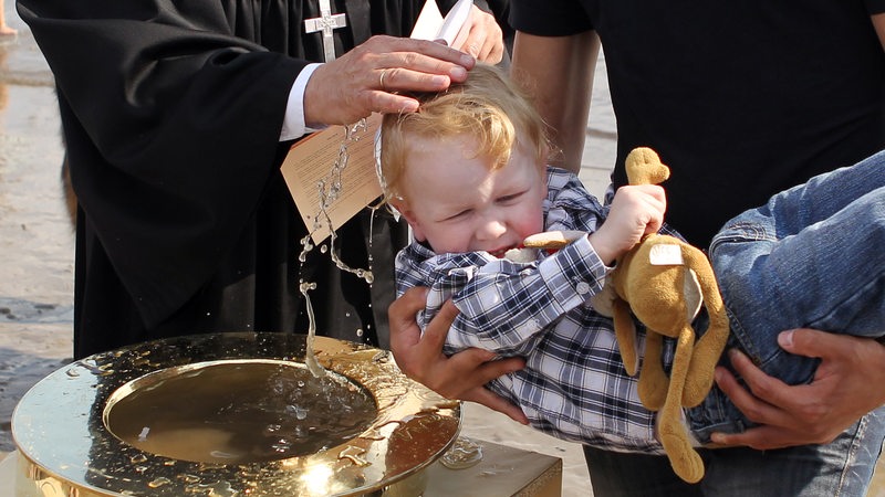Ein Junge ca. 3jähriger Junge wird getauft.