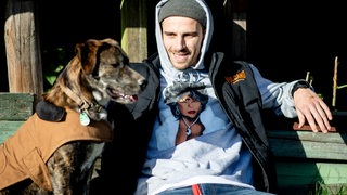 Fynn Kliemann, deutscher Musiker und YouTuber, sitzt mit seinem Hund Giuseppe auf seinem Hof "Kliemannsland" im Ortsteil Rüspel. 