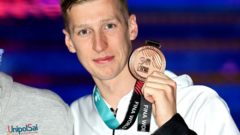 Florian Wellbrock posiert mit der Bronze-Medaille.
