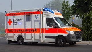 in Rettungswagen, RTW, steht mit Blaulicht und Schriftzug Rettungsdienst in einem Kreisverkehr. 