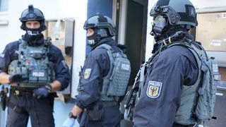 Polizisten bei Durchsuchungen. Die Beamten gingen gegen Schleuserbanden vor.