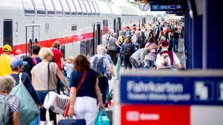 Menschen steigen am Bahnsteig in Norddeich-Mole in den IC ein.