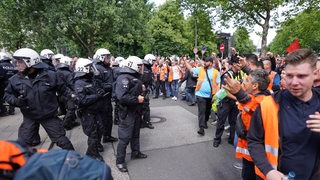 Bei einer Demonstration von Hafenarbeitern stehen sich Streikende und Polizisten gegenüber