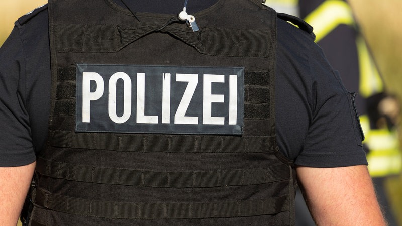  Ein Beamter der Polizei mit Weste und dem Aufdruck Polizei. (Symbolbild)