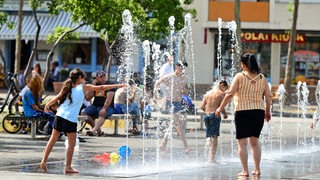 Während der Hitze suchen Menschen wie hier in Mannheim Abkühlung.