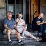 Ältere Menschen suchen Abkühlung im Schatten eines Geschäfteingangs.