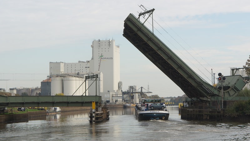 Frachtschiff während der Durchfahrt unter der Oldenburger Eisenbahnklappbrücke über die Hunte.