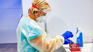 Die Mitarbeiterin eines Testzentrums präpariert einen Corona-Schnelltest