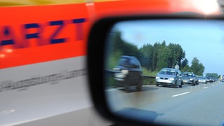 Ein Notarzt fährt durch eine Rettungsgasse.