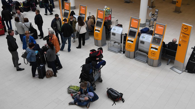 Fluggäste warten im Airport Bremen darauf, das der Lufthansa Check-In Schalter öffnet.