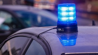 Ein eingeschaltetes Blaulicht auf einem Zivilfahrzeug der Polizei. 