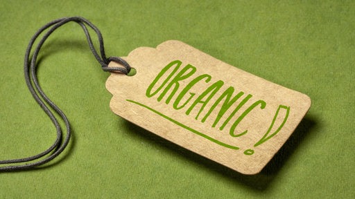 "Organic" steht auf einem Papierlabel vor grünem Hintergrund. 