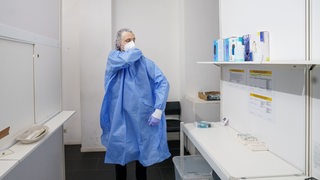 Ein Mitarbeiter einer Teststation bereitet sich auf die Durchführung eines Coronatests vor.