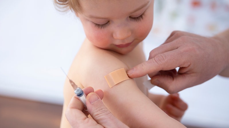 Ein Kind erhält ein Pflaster nach einer Impfung.