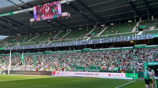 Werder-Fans kritisieren auf einem Banner die Maßnahmen der Polizei beim Spiel in Wolfsburg.