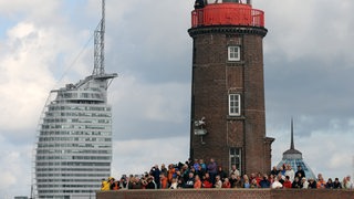 Zahlreiche Besucher der "Sail 2010" in Bremerhaven haben sich zur Einlaufparade auf dem Leuchtturm der Nordmole eingefunden. 