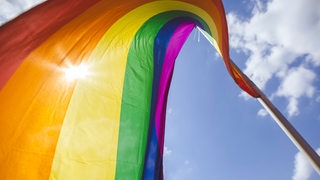 Eine Regenbogenfahne weht auf einem Gebäude in Berlin