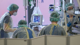 Pflegerinnen und Pfleger sowie eine Ärztin kümmern sich auf der Intensivstation für Corona-Patienten am Sana Klinikum Offenbach um einen Patienten. 