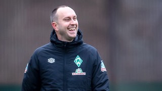 Werder-Trainer Ole Werner lacht beim Training.