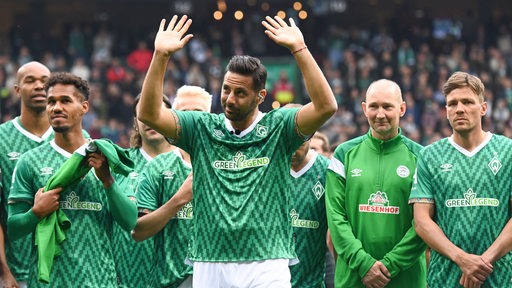 Claudio Pizarro steht bei seinem Abschiedsspiel neben anderen Werder-Spielern und winkt den Fans zu.