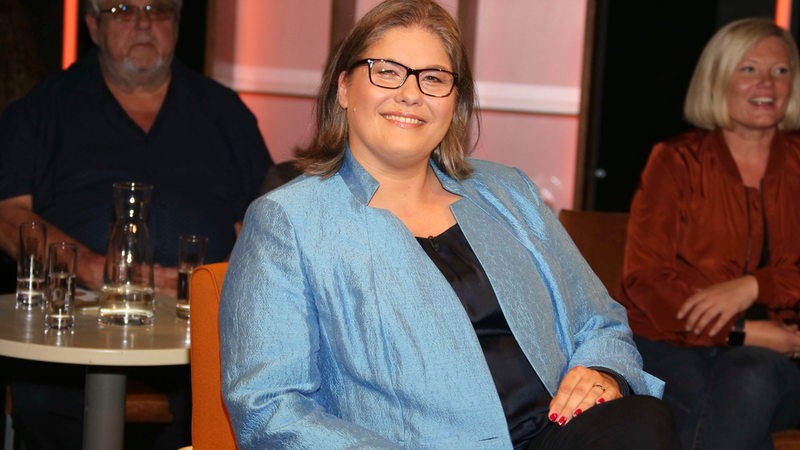 Annabel Oelmann, Chefin der Bremer Verbraucherzentrale, sitzt in einem TV-Studio und lächelt in die Kamera.